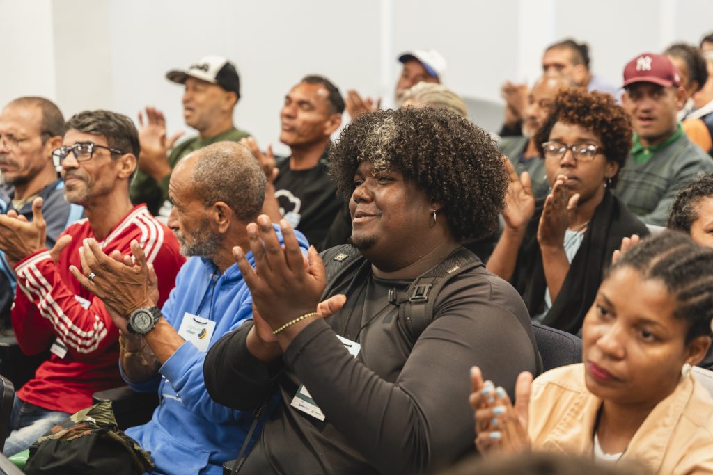 Participantes aplaudindo durante encontro do projeto Comum Viver